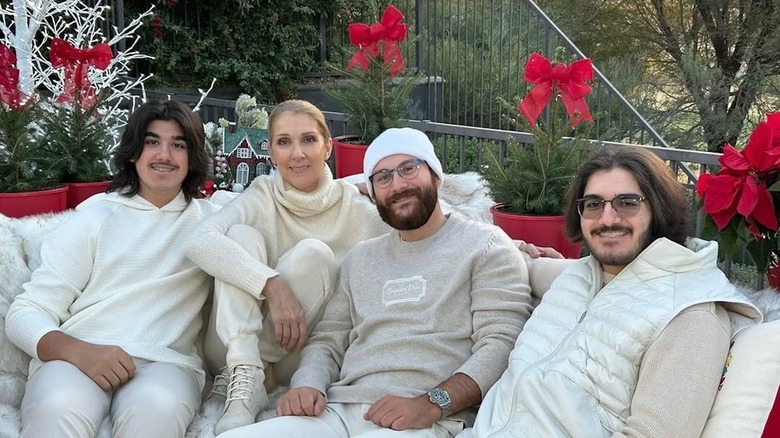 Céline Dion sits outdoors with her three sons