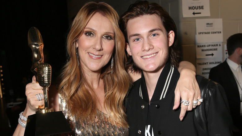 Celine Dion holds an award while posing with her son, René-Charles Angélil