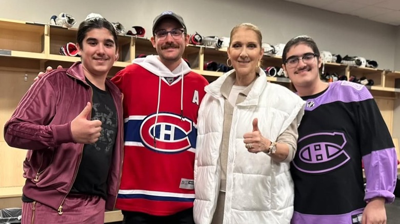 Céline Dion poses with her sons in a hockey locker room