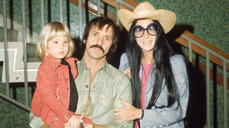 Cher smiling for a photo with Sonny Bono and Chaz Bono