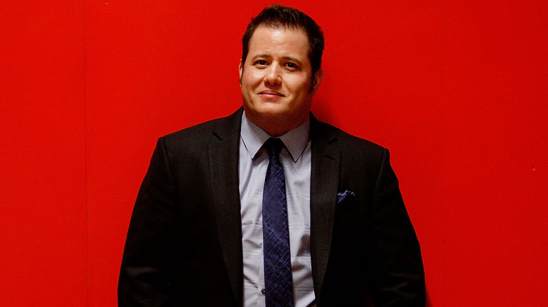 Chaz Bono posing against red background