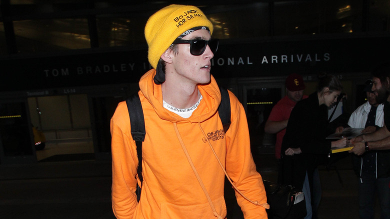 Presley gerber walking through airport with sunglasses on