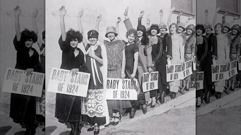 Clara Bow standing in front of a line of women holding signs