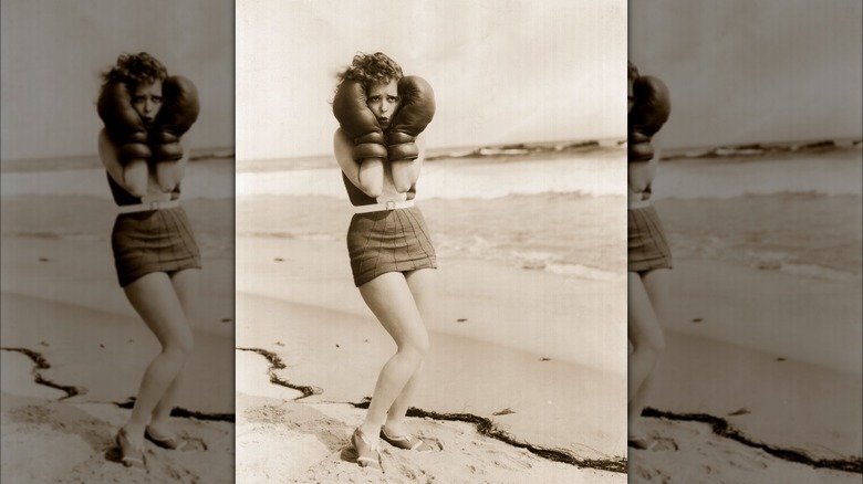 Clara Bow posing with boxing gloves on a beach 