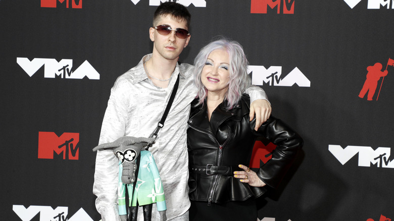 Declyn Lauper in gray shirt and pants with Cyndi Lauper with gray hair and black leather jacket