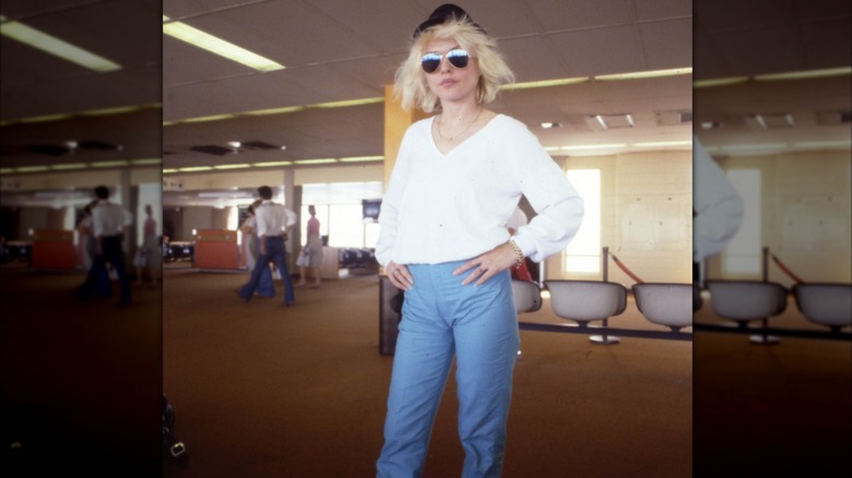 Debbie Harry in sunglasses, black hat, white shirt and jeans