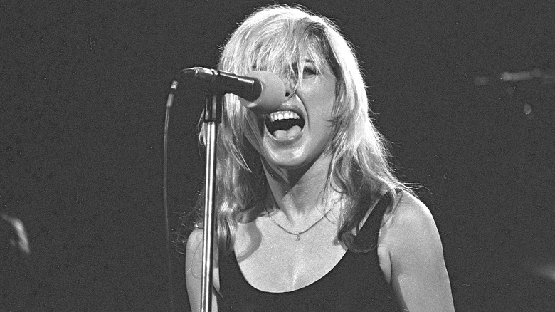 Debbie Harry singing on stage in black tank top