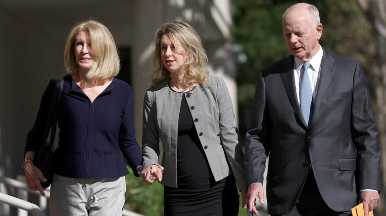 Elizabeth Holmes arrives to court pregnant, accompanied by her parents