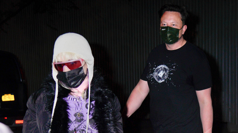 Paparazzi shot of Grimes and Elon Musk wearing masks