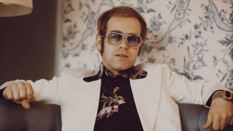 Elton John sitting on chair