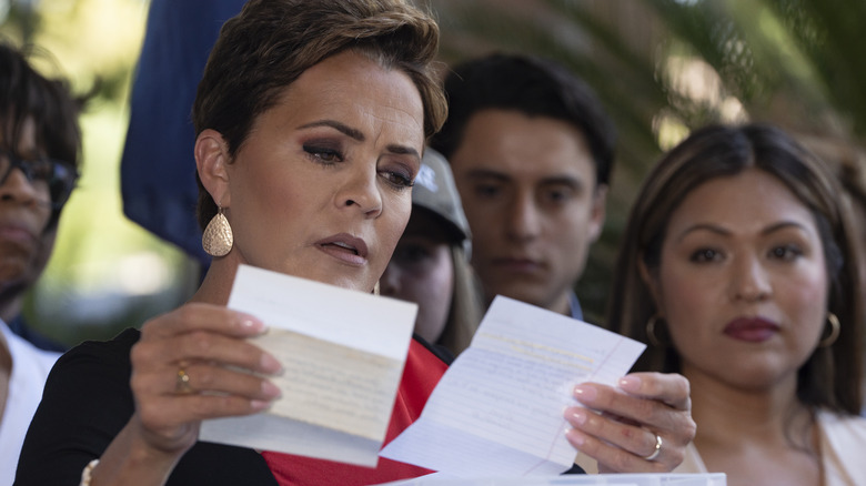 Kari Lake reading notes while addressing a crowd