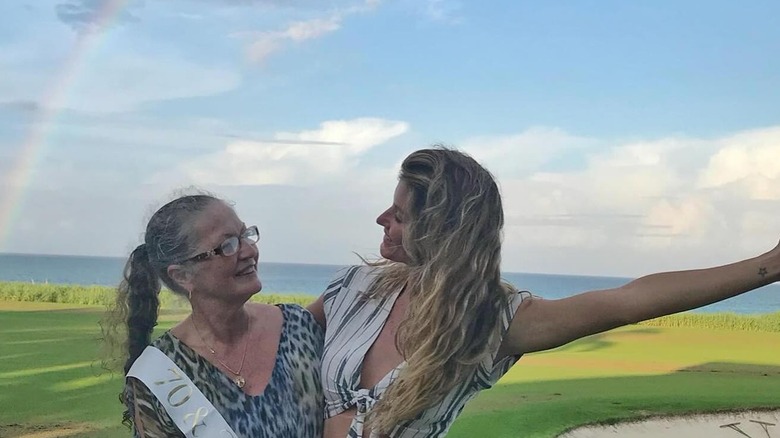 Gisele Bundchen and her mother in front of a rainbow