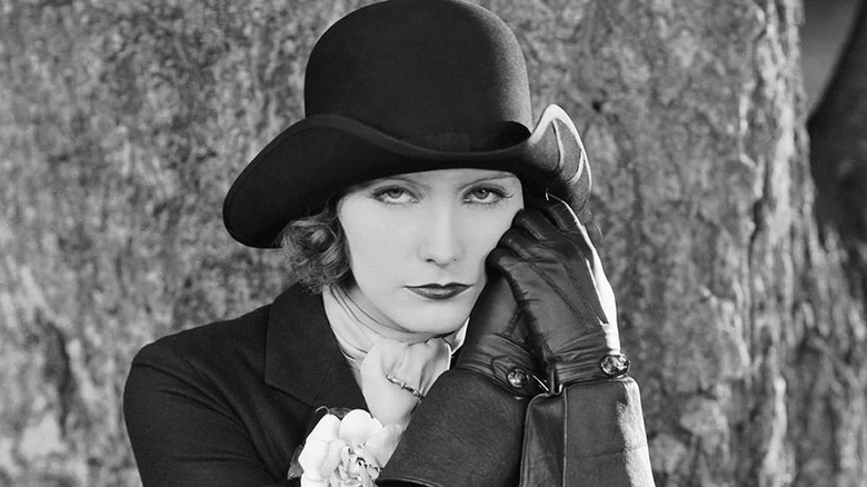 Greta Garbo posing in black hat and gloves