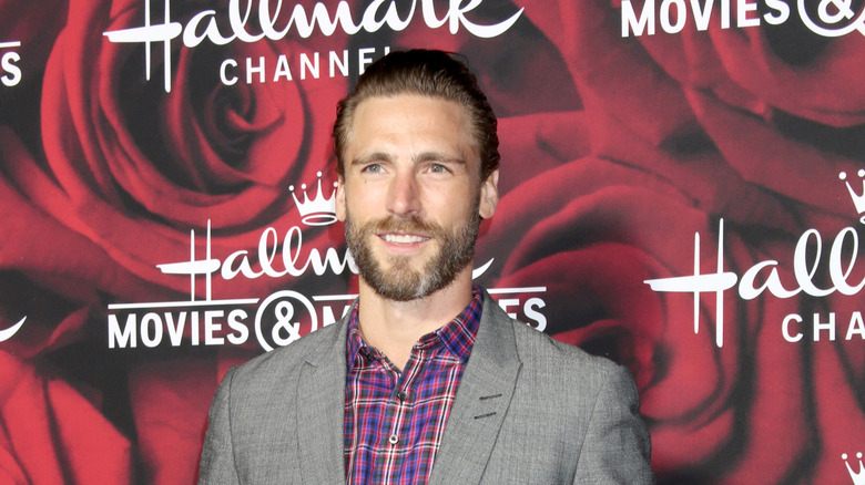 Andrew Walker smiling in a gray suit at an event