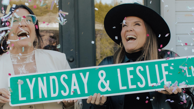 Lyndsay Lamb and Leslie Davis holding up a street sign with their names on it