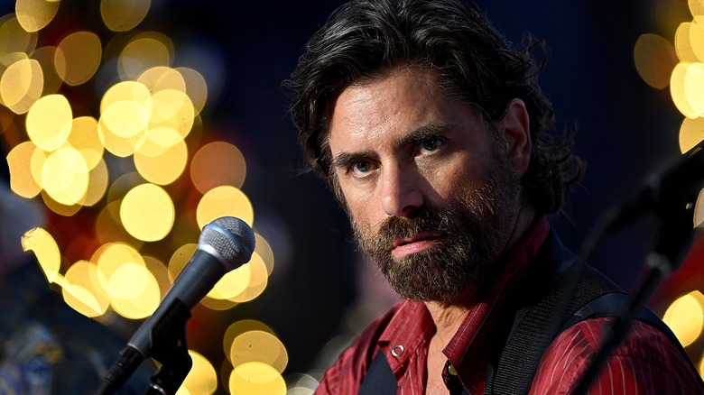 actor John Stamos with a microphone