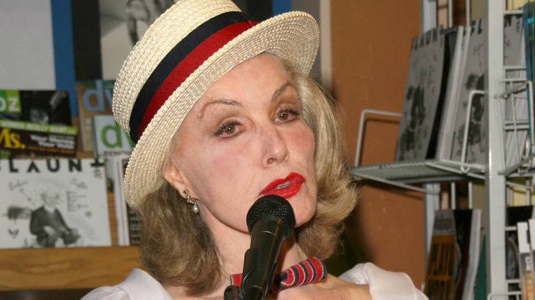 Julie Newmar speaking into microphone