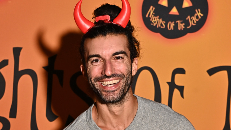 Justin Baldoni on the red carpet in devil horns