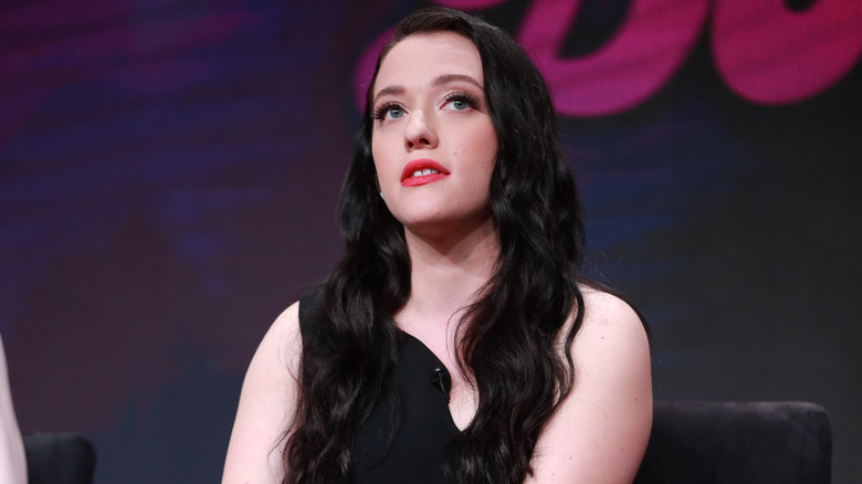 Kat Dennings sitting on stage