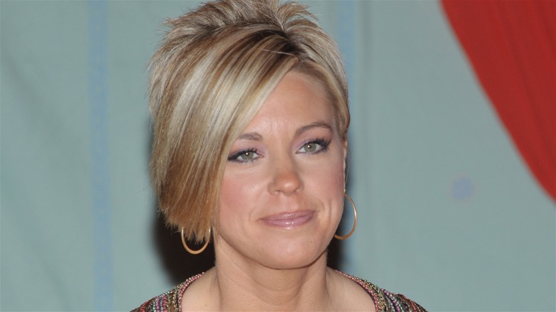 Kate Gosselin against a grey background with big hoop earrings