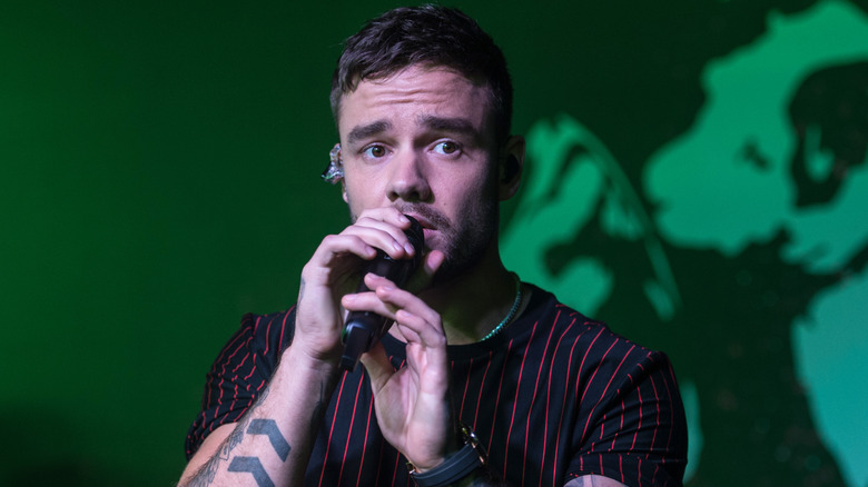 Liam Payne performing on stage holding microphone