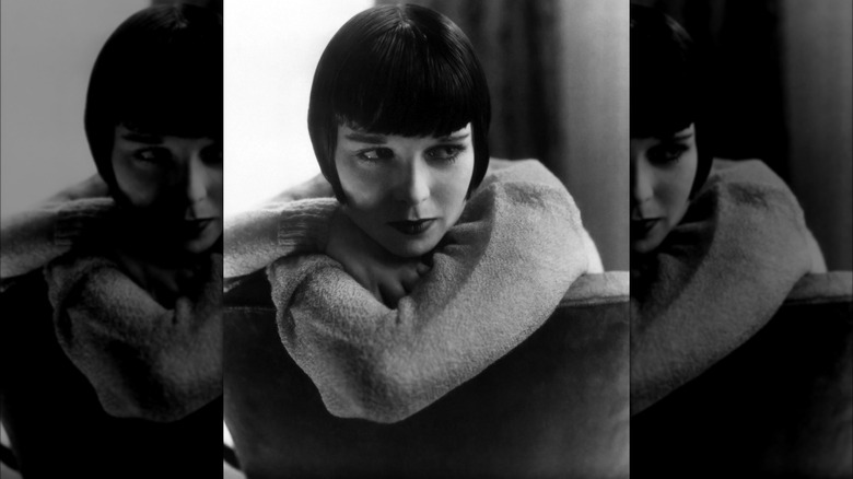 Louise Brooks leaning on the back of a chair