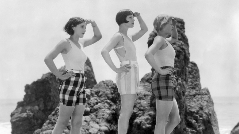 Louise Brooks poses on a rock with two women 