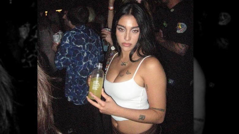 Lourdes Leon smirking in a crop top at a party