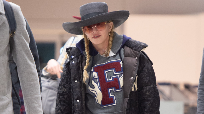 Madonna wearing a hat and oversized sunglasses