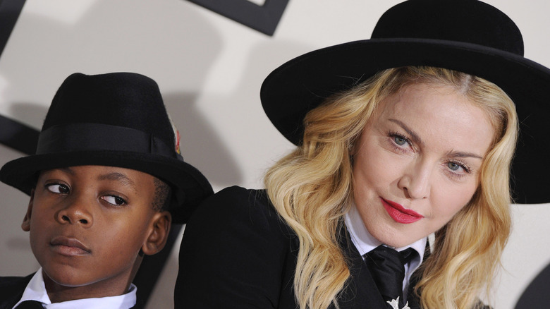 young David Banda and Madonna posing together in black hats