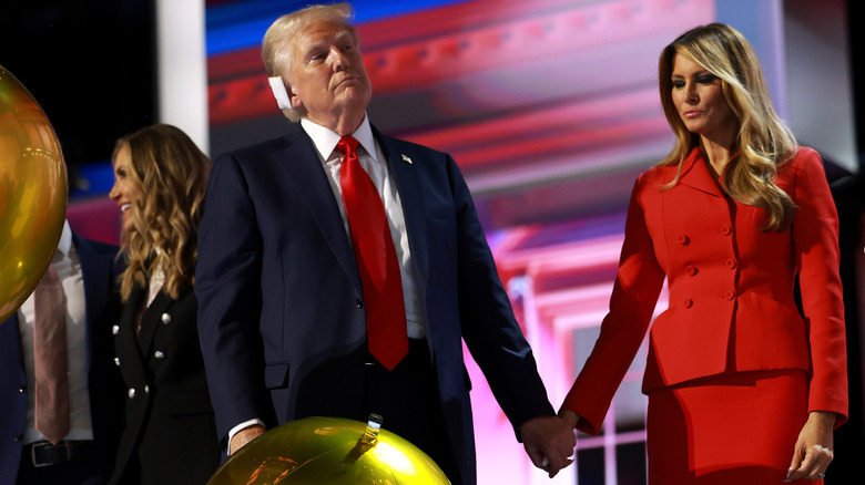 Melania Trump holding a bandaged Donald Trump's hand