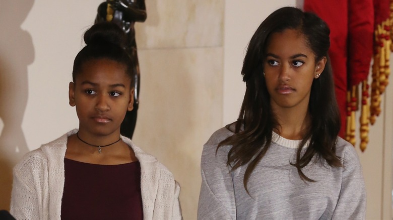 Sasha and Malia Obama standing together