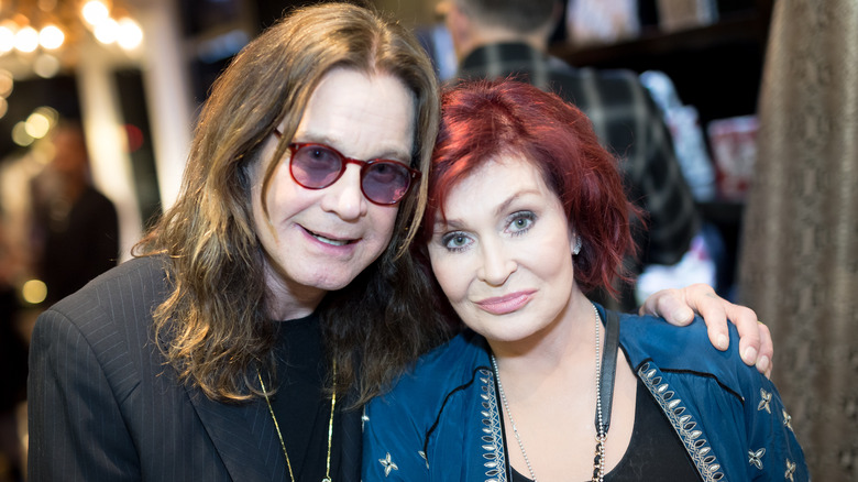 Sharon Osbourne and Ozzy Osbourne smiling for photos