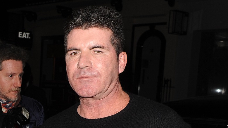 Simon Cowell exiting a restaurant