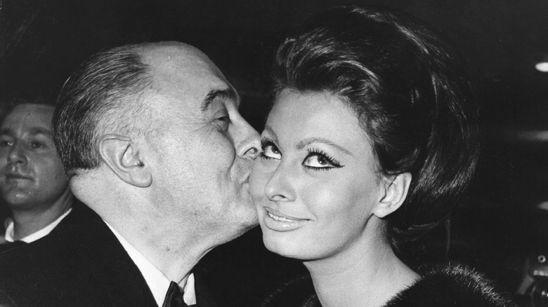 Carlo Ponti kissing Sophia Loren on cheek