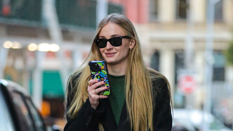 Sophie Turner walking outside on her phone