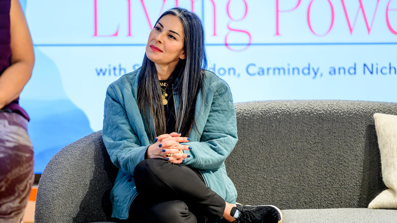 Stacy London sitting on a couch