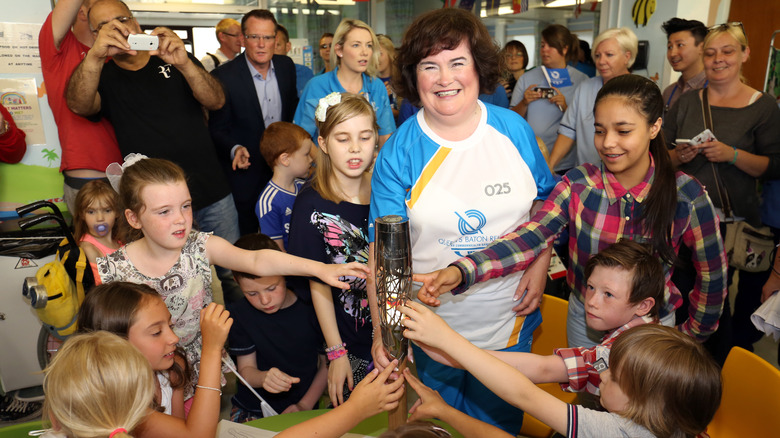 Susan Boyle smiling with group of children