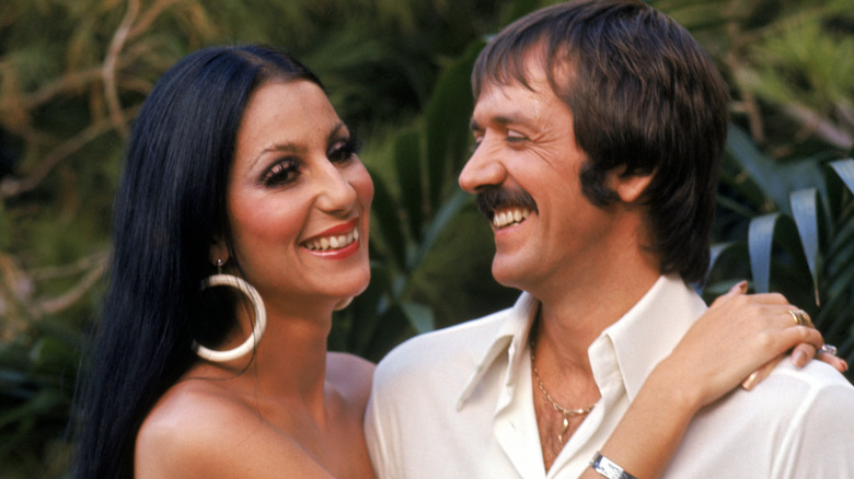 Cher smiling with her arms around Sonny Bono