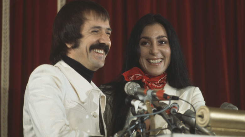 Sonny and Cher smiling in front of microphones