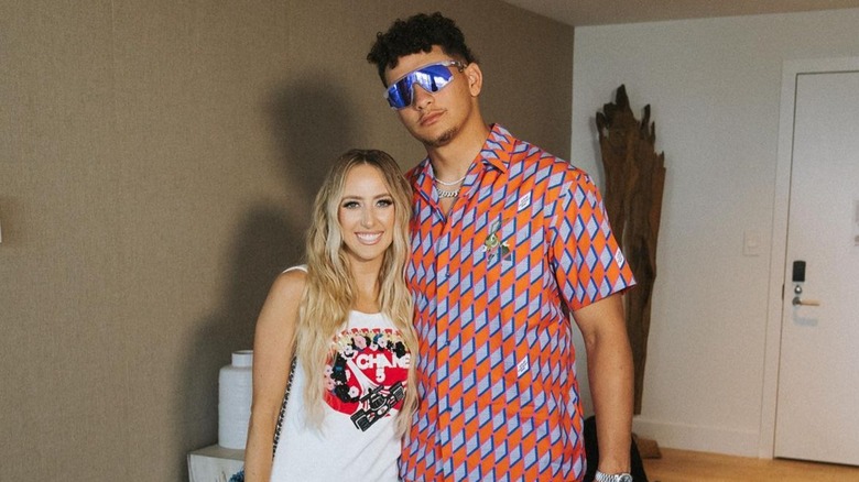 brittany and patrick mahomes posing in an apartment