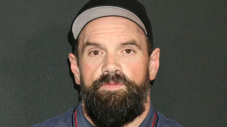 Ethan Suplee standing against a black background