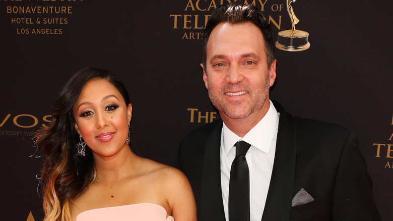 Tamera Mowry smiles next to her husband Adam Housley