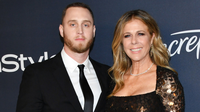 Chet Hanks in black suit and tie with mom Rita Wilson in gold sequin gown at InStyle event