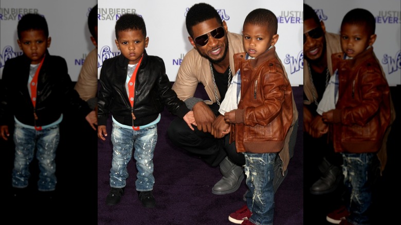 Usher smiling with his two sons 