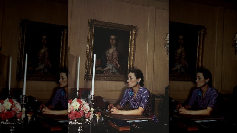 Wallis Simpson sits a desk 