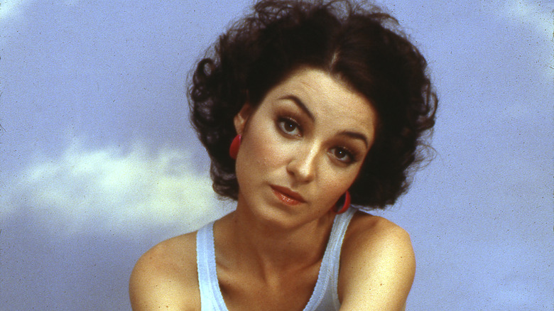 Young Annie Potts in front of sky backdrop