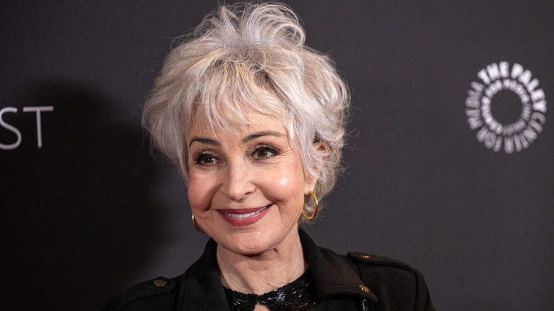 Annie Potts smiling in front of black backdrop