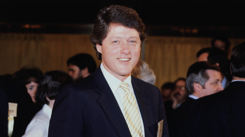 Bill Clinton smiling at crowded event