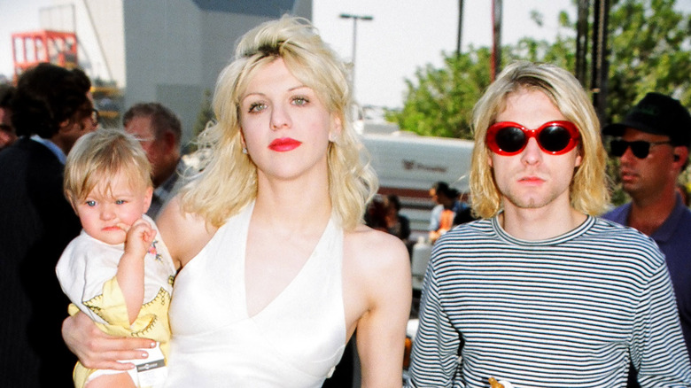 Courtney Love and Kurt Cobain walking with Frances Bean as a baby